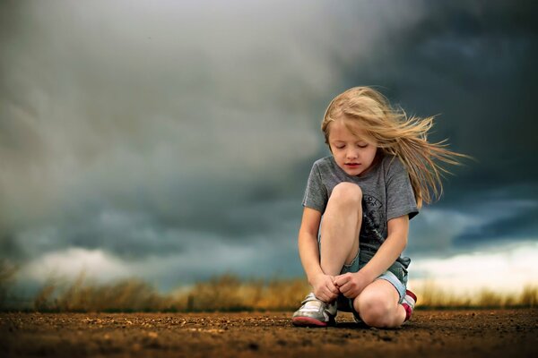 La fille est sous les nuages sur la route