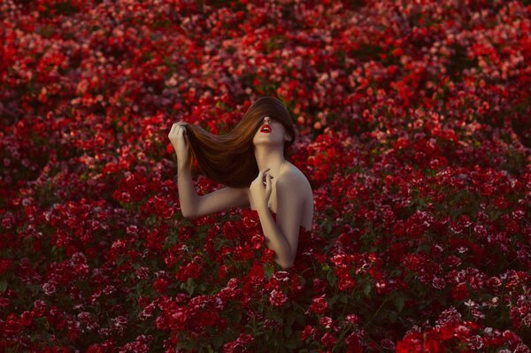 A girl with loose hair and beautiful makeup in flowers