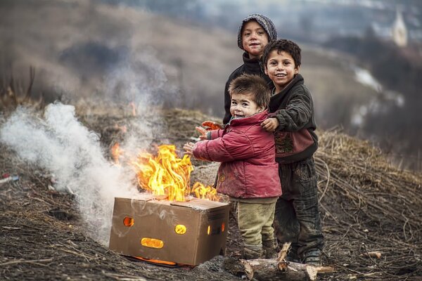 Szczęśliwe twarze dzieci wygrzewających się przy ognisku