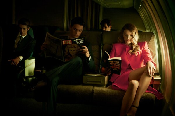 Lily Donaldson and the man next to her in the cabin of the plane reading a magazine