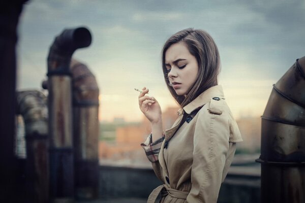 La fille de Catherine Lemaire urbaine sur le toit avec une cigarette