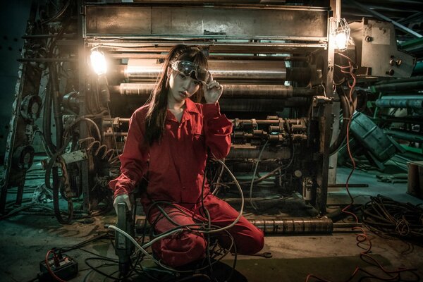 A beautiful Asian woman works as a welder and raises her glasses