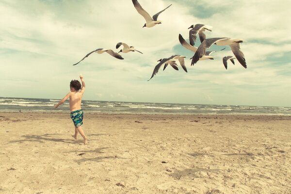 Dziecko biegnie za mewami na plaży Retro filtr