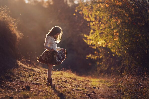 Ragazza in bel vestito nella foresta d autunno. Raggi solari