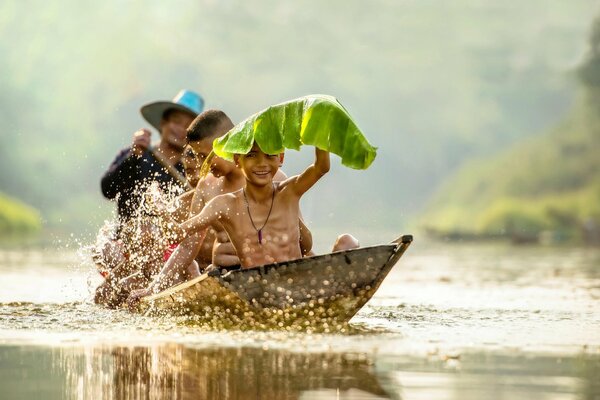 Bambini che navigano su una barca che schizza in acqua