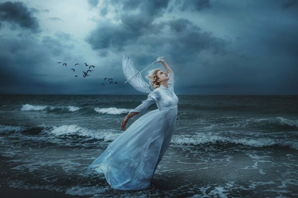 Fairy on the seashore during a storm surrounded by birds