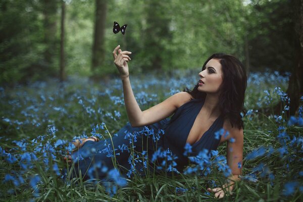 Mädchen sitzt in blauen Farben im Wald