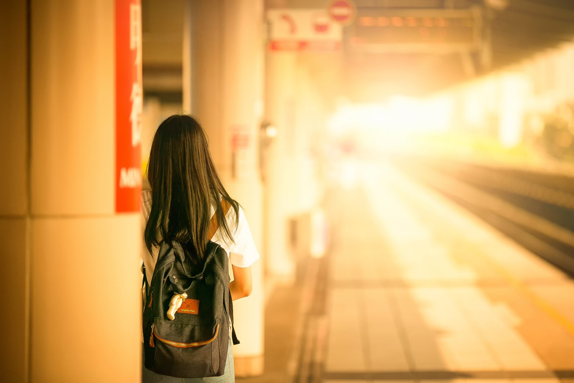 chica mochila estación de tren buen viaje