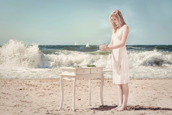 La jeune fille en robe blanche sur le front de mer