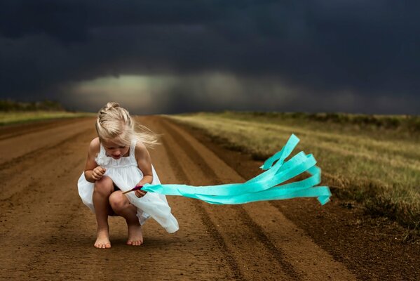 The girl sat down on the road