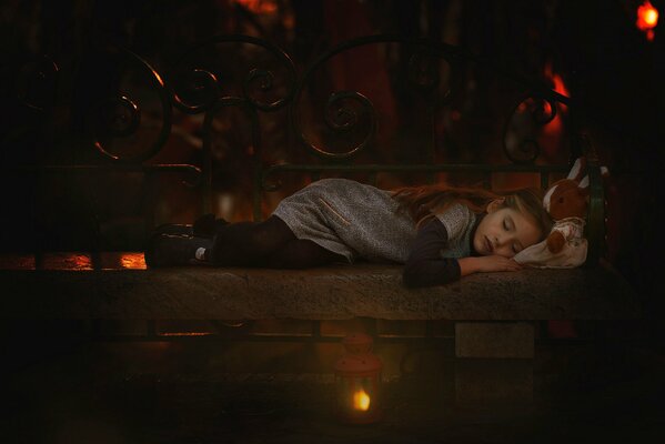 Una ragazza addormentata su una panchina accanto a un giocattolo fa un sogno