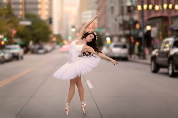 A ballerina performs a step on the roadway