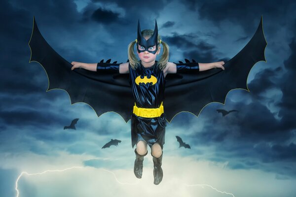 Маленькая девочка летит в маске и костюме Бэтмена