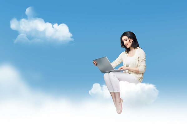Brünette Mädchen in einem Anzug mit einem Laptop sitzt auf einer Wolke