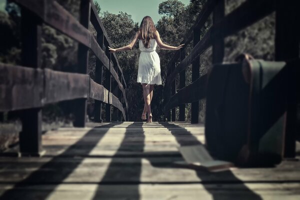 A walk across the bridge. A girl in a white dress