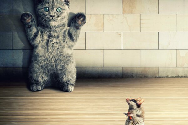 A kitten with raised paws and a mouse with a gun