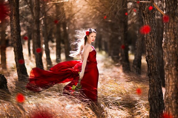 A girl in a red dress in the forest