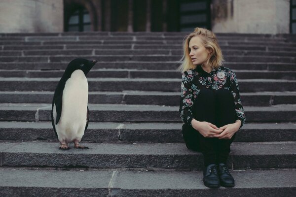 Chica con pingüino sentado en las escaleras