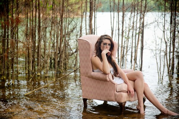 A girl in a chair against the background of the forest