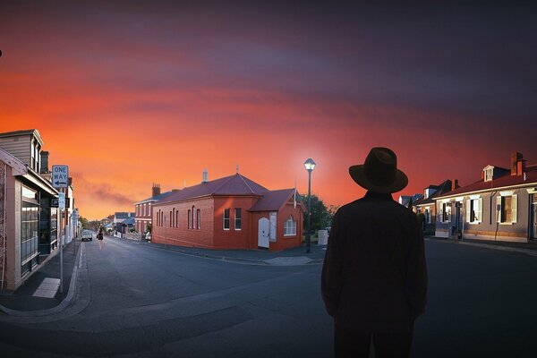 The man in the hat in the city at the fork of the road