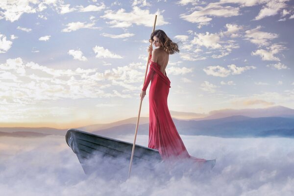 Beautiful photo of a girl in a red dress on a boat in the fog