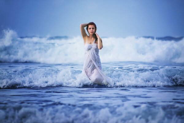 Beautiful girl in the waves of the ocean