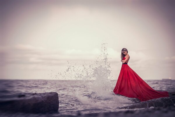 A girl in a red dress on the seashore