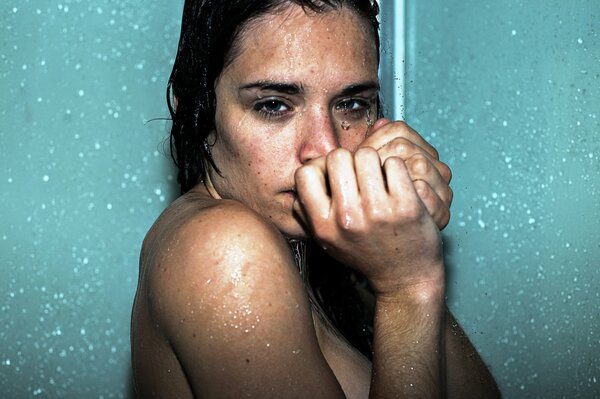 Mädchen mit dunklen Haaren steht unter der Dusche