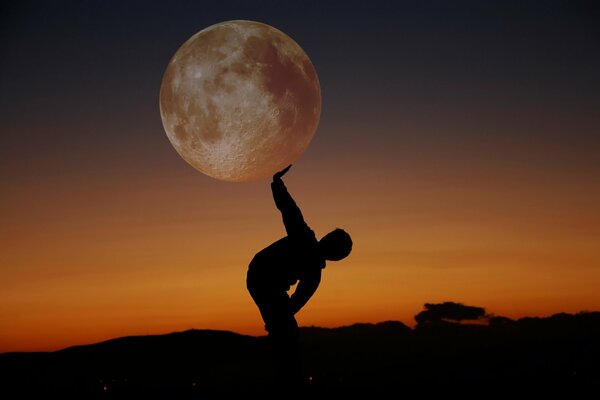 A dark silhouette of a man against the background of a full moon