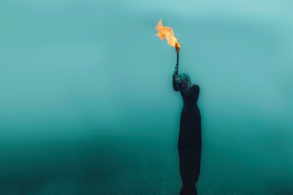 Fille avec une torche sur fond de ciel