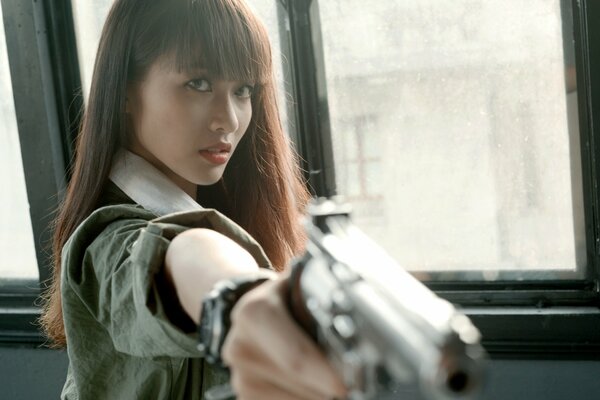 Beautiful girl with a gun in her hands