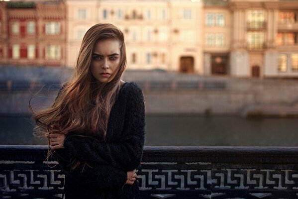 A gloomy girl on the background of a building