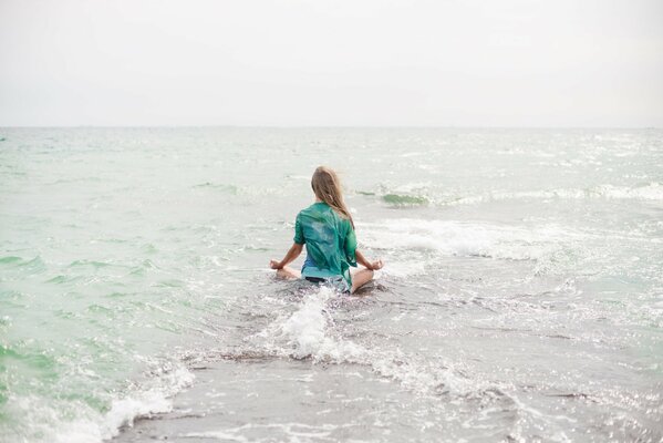 Blondine macht yoga am Meer