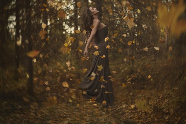 La jeune fille dans un tourbillon de feuilles