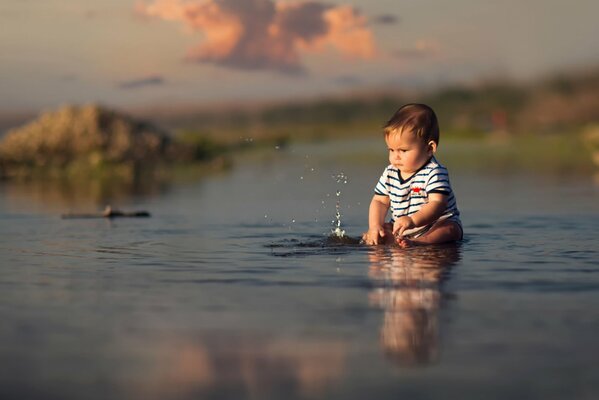 Мальчик плещется в воде