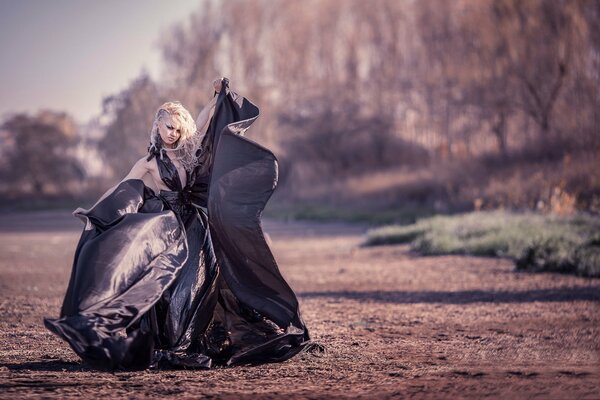 Mädchen in einem langen schwarzen Kleid