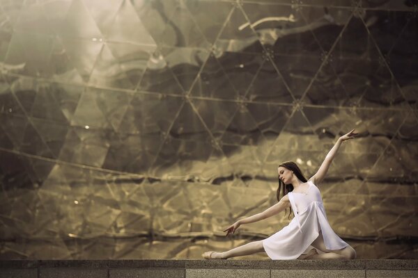 Eine Ballerina führt einen Tanz an einer Spiegelwand auf