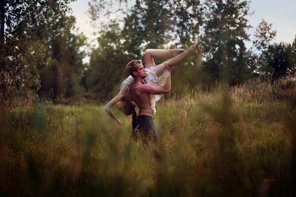 Chico con chica en la naturaleza bailando