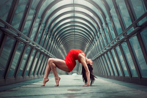 A gymnast girl in red with a beautiful figure and slender legs