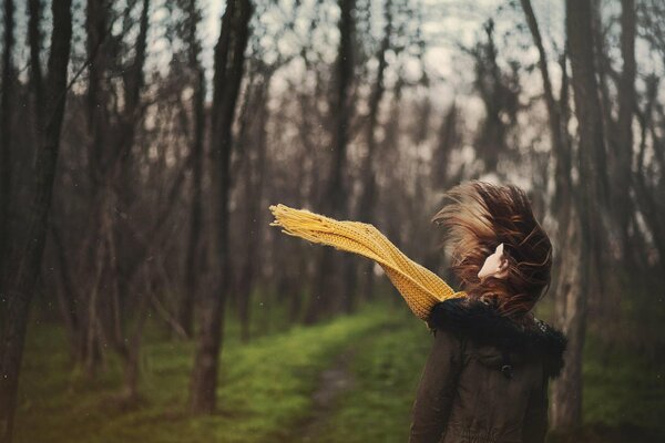 Chica en el bosque en una bufanda amarilla