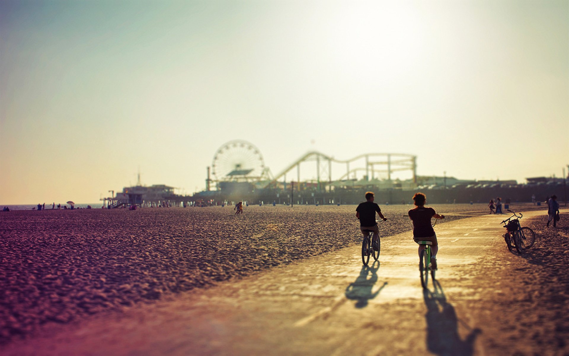 promenade couple vélos route plage soirée coucher de soleil grande roue montagnes russes