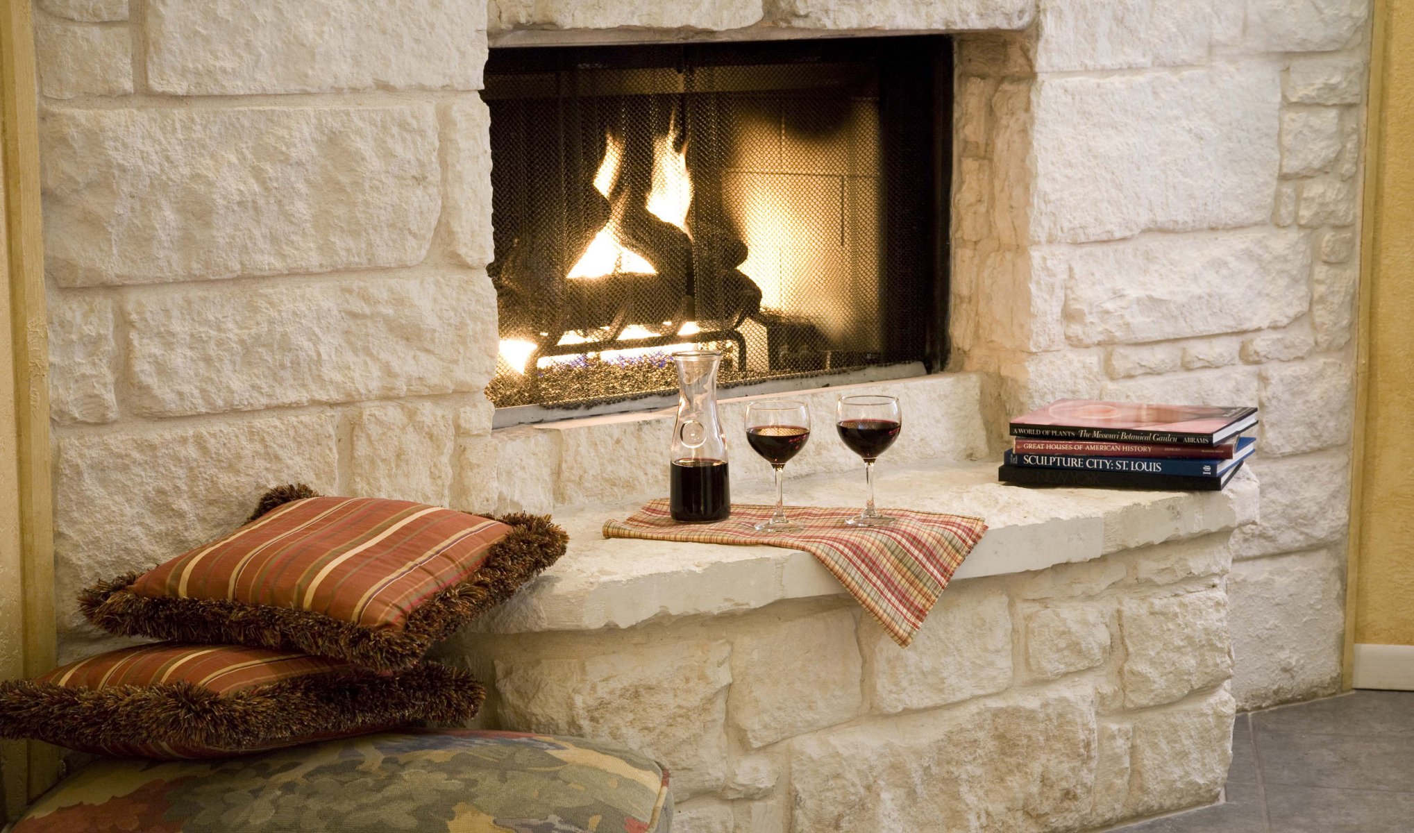 fireplace pillow glasses wine books romance