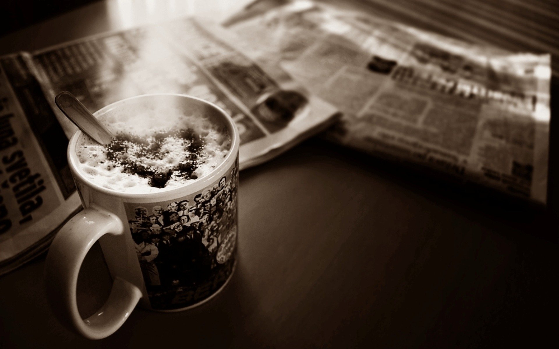 tazza caffè schiuma cuore giornali scrivania foto seppia