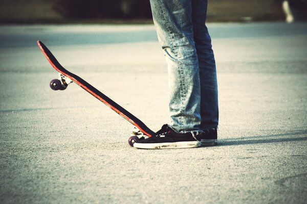 Ragazzo in jeans su uno skateboard