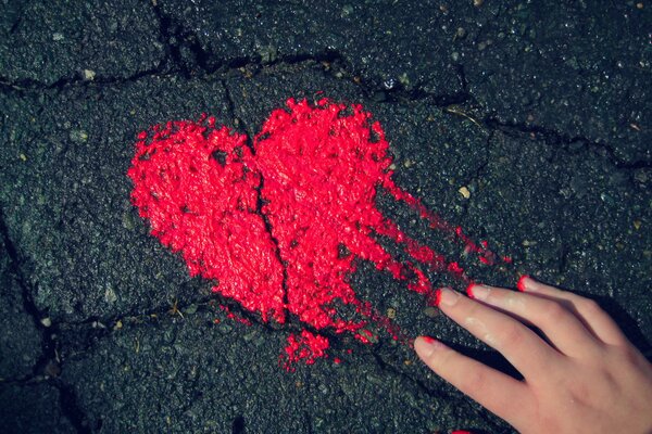 Coeur peint avec de la peinture rouge sur l asphalte