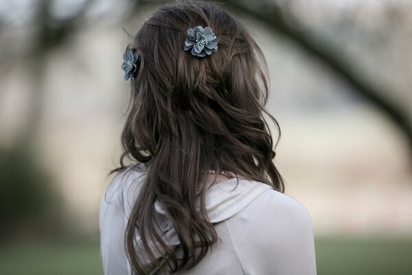 Chica de atrás con el pelo largo y flores tejidas en ellos