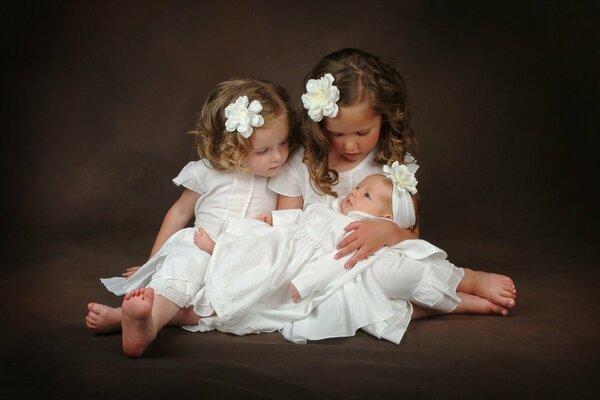 Photo of two girls taking care of a baby