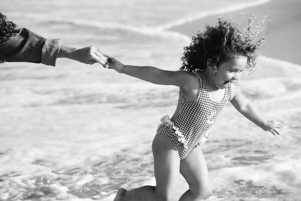 Chica rizada corriendo a nadar en el mar