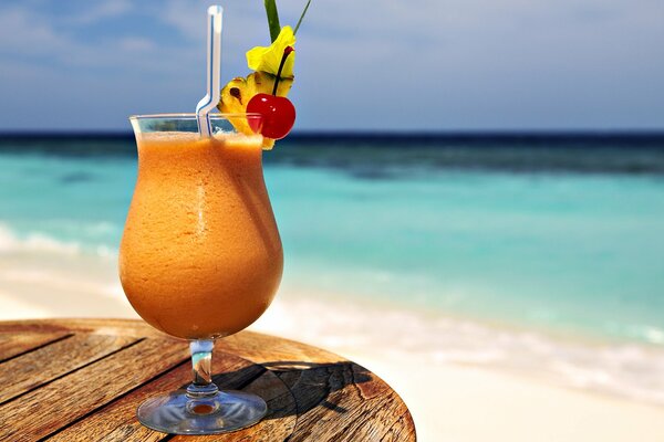 View of the white sand and the laser sea with a cocktail and handles