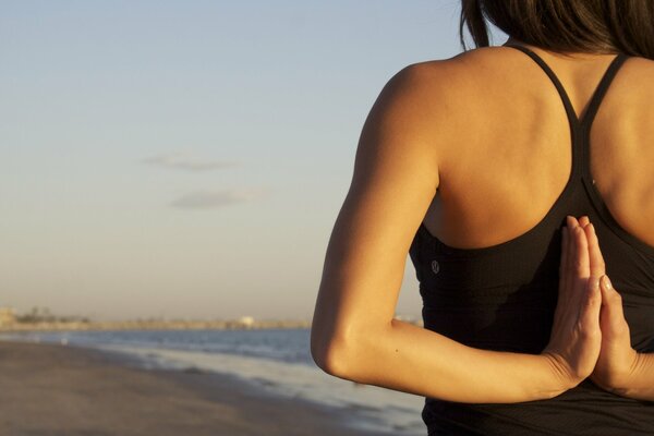 Ragazza che fa yoga in riva al mare